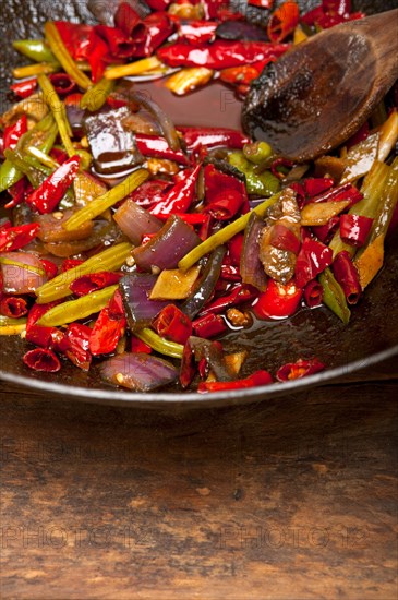 Fried chili pepper and vegetable on a iron wok pan