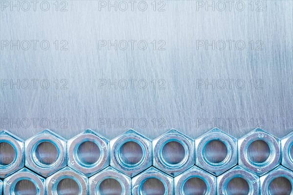 Copy Space image of stainless steel construction nuts on a metallic background Repair concept