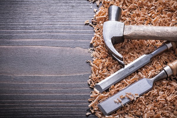 Claw hammer flat chisel and wooden shavings on vintage wooden board copy room picture building concept