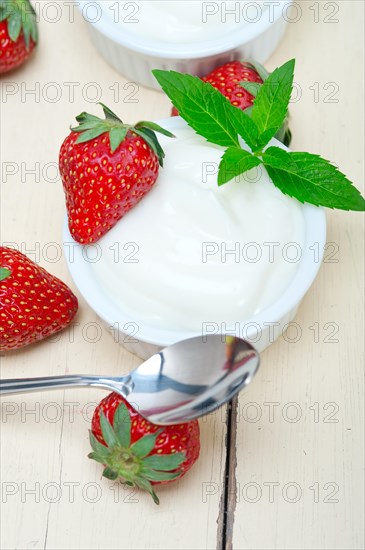 Organic Greek yogurt and strawberry over white rustic wood table