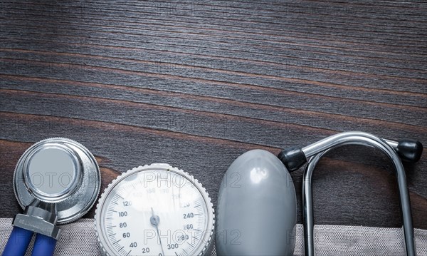 Copy room image of stethoscope and blood pressure monitor on vintage wooden medicine board concept