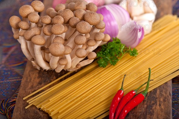 Italian pasta and mushroom sauce raw ingredients over rustic old wood