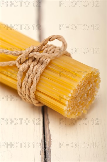 Italian pasta spaghetti tied with a rope on a rustic table