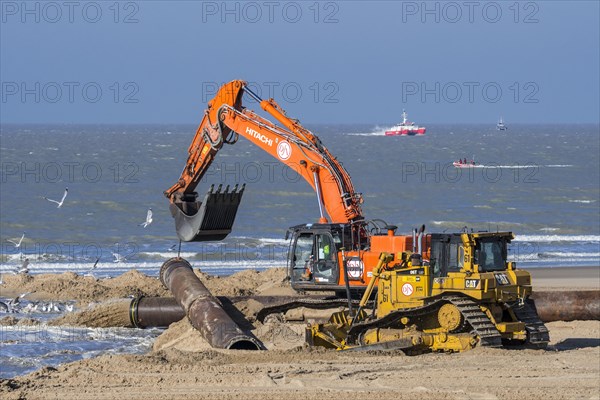 Bulldozer and hydraulic excavator installing pipeline during sand replenishment