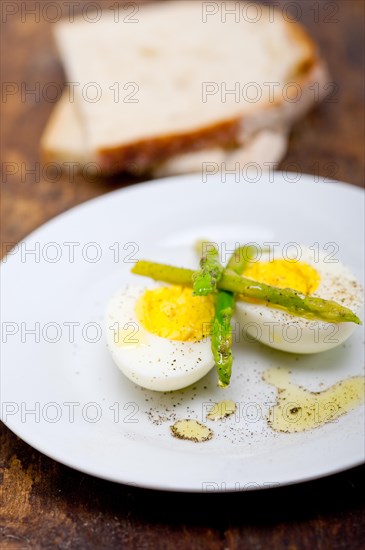 Boiled fresh green asparagus and eggs with extra virgin olive oil with rustic bread