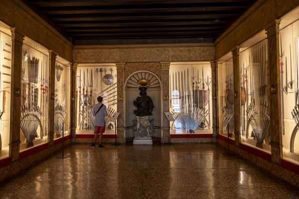 Young man in an exhibition room with medieval weapons