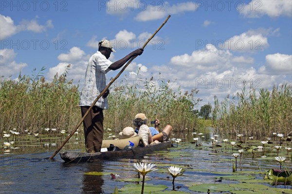 Tourists traveling in traditional wooden canoe