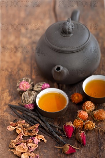 Chinese style herbal floral tea over wood table with raw ingredients