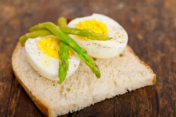 Boiled fresh green asparagus and eggs with extra virgin olive oil with rustic bread