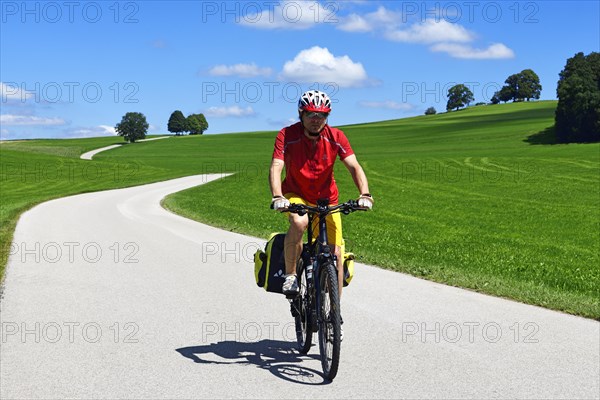 Cyclist on a picture-book country road near Berg