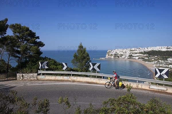 Cyclist on the pass road near San Nicola with a view of Peschici