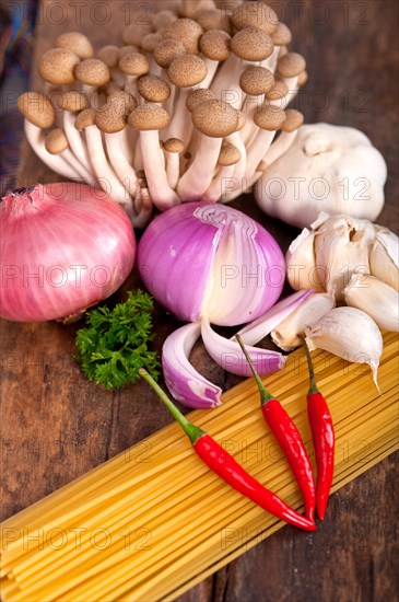 Italian pasta and mushroom sauce raw ingredients over rustic old wood