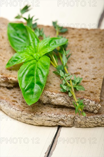 Rustic Italian bread basil and thyme simple snack on white wood table