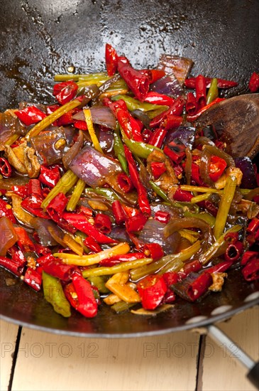 Fried chili pepper and vegetable on a iron wok pan