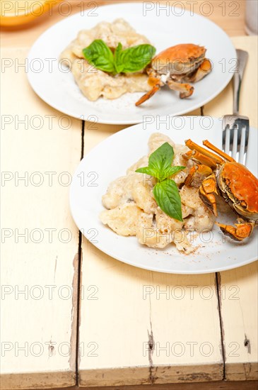 Fresh homemade Italian gnocchi with seafood sauce crab and basil