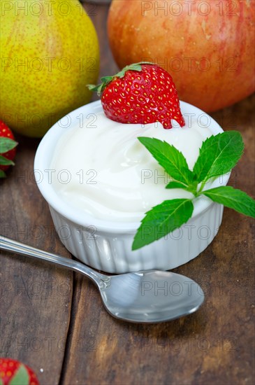 Fresh fruits and whole milk yogurt on a rustic wood table