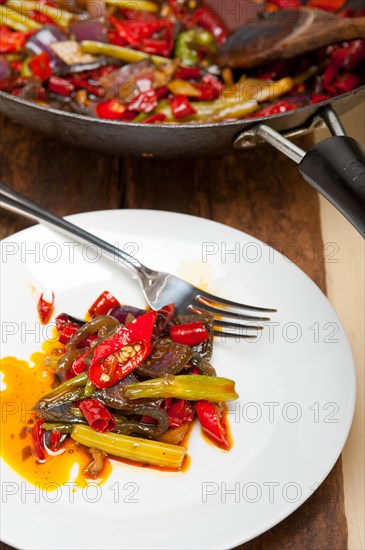 Fried chili pepper and vegetable on a iron wok pan