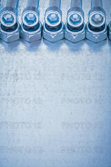 Group of threaded nuts and bolts details on metallic background copy space image construction concept