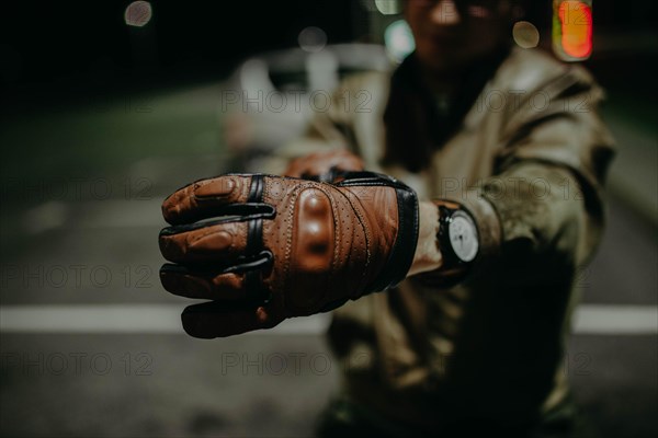 A motorcyclist shows his brown leather touring glove to the camera