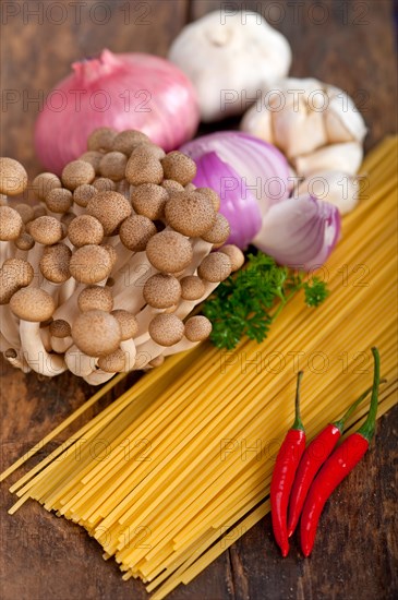 Italian pasta and mushroom sauce raw ingredients over rustic old wood