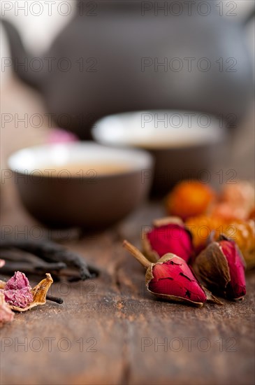 Chinese style herbal floral tea over wood table with raw ingredients