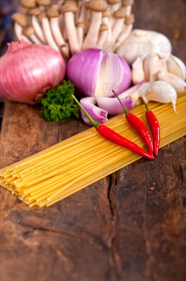 Italian pasta and mushroom sauce raw ingredients over rustic old wood