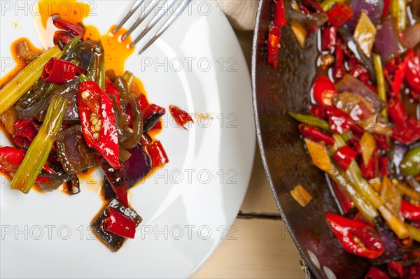 Fried chili pepper and vegetable on a iron wok pan