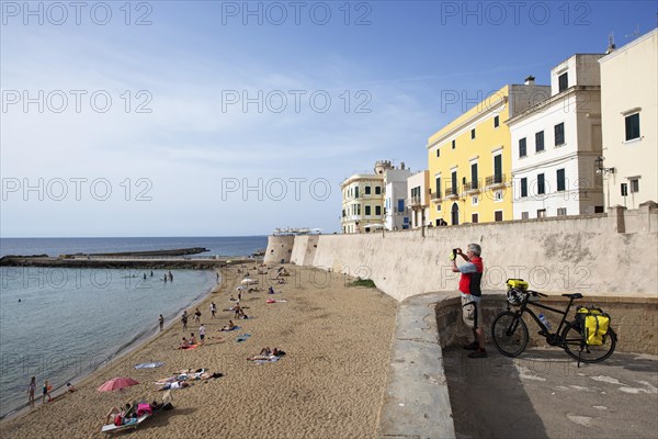 Cyclist on the city beach Seno della Purita