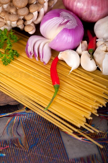 Italian pasta and mushroom sauce raw ingredients over rustic old wood