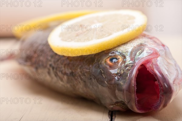 Fresh whole raw fish on a wooden table ready to cook