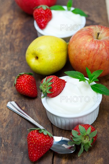 Fresh fruits and whole milk yogurt on a rustic wood table