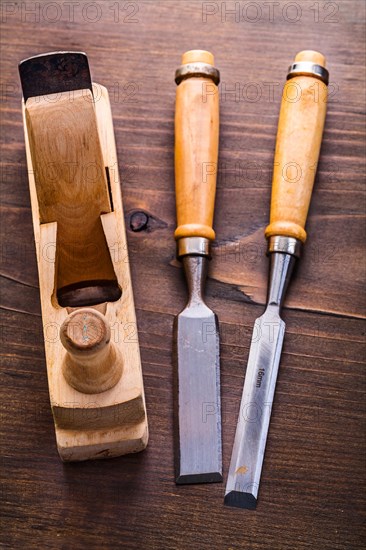 Chisel and wooden plane on an old wooden board