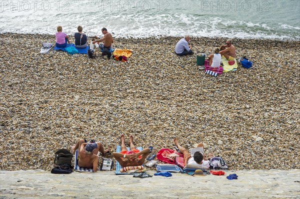Sunbathers sunning on shingle beach along the North Sea coast