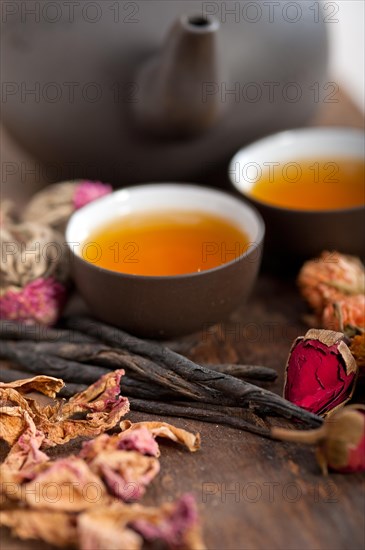 Chinese style herbal floral tea over wood table with raw ingredients