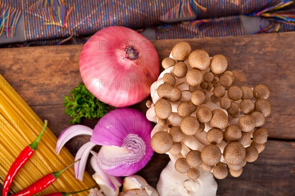 Italian pasta and mushroom sauce raw ingredients over rustic old wood