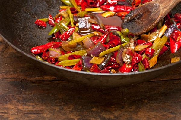 Fried chili pepper and vegetable on a iron wok pan