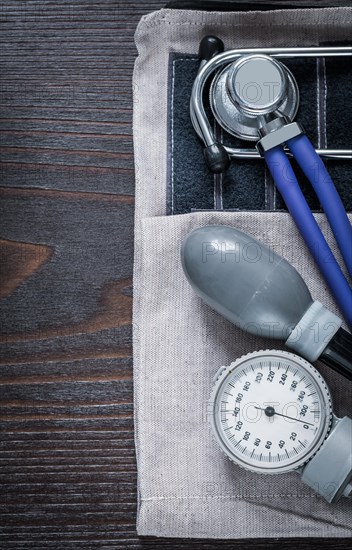 Close up image of stethoscope and blood pressure monitor on vintage wooden background medicine concept