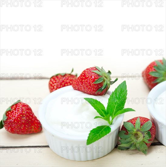 Organic Greek yogurt and strawberry over white rustic wood table