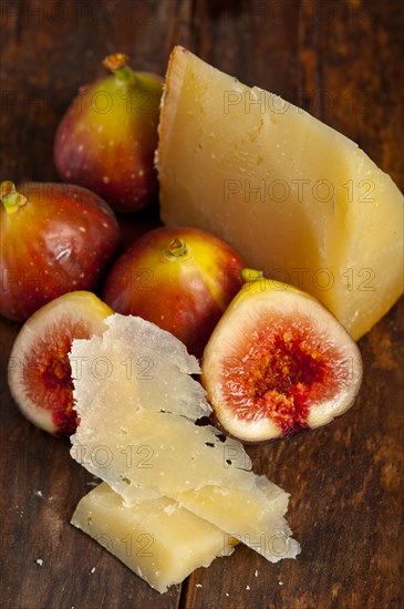 Italian pecorino cheese and fresh figs macro closeup over old wood boards