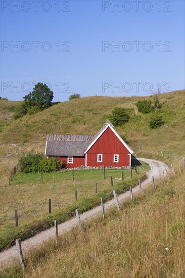 Traditional red wooden farmhouse with thatched roof