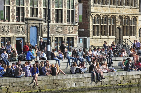 People enjoying the first spring sun by the waterside along the Graslei at Ghent