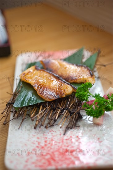 Japanese style teppanyaki roasted cod fish on palm leaf