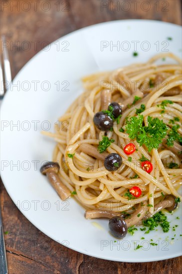 Italian pasta and mushroom sauce over rustic old wood