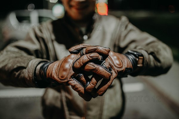 A motorcyclist shows his leather brown gloves for a touring trip to the camera