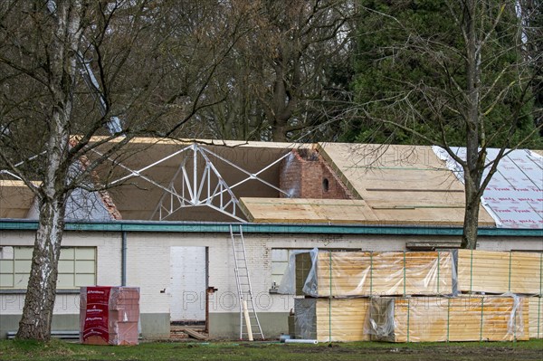 Building fitted with warm pitched roof insulation by installing insulating sandwich panels