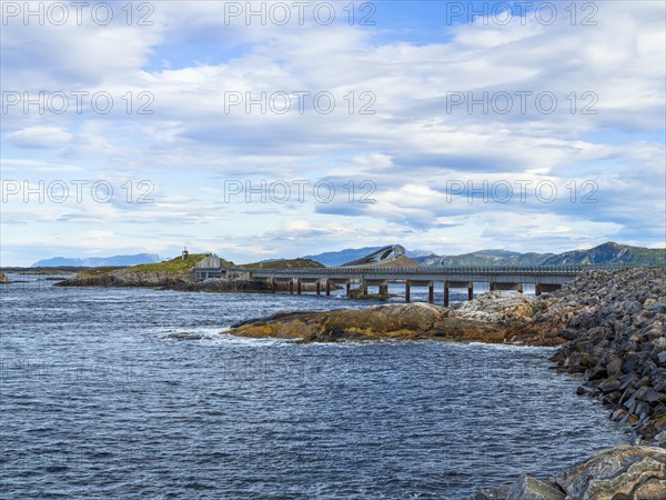 Bridge connecting rocky shores under a cloudy sky