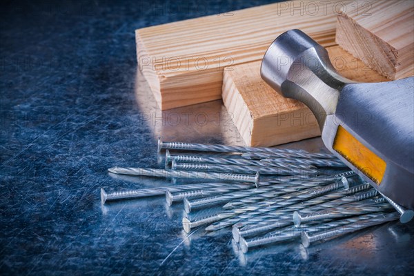 Construction nails claw hammer and wooden bolts on scratched metallic background Maintenance concept