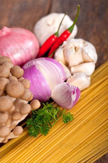 Italian pasta and mushroom sauce raw ingredients over rustic old wood