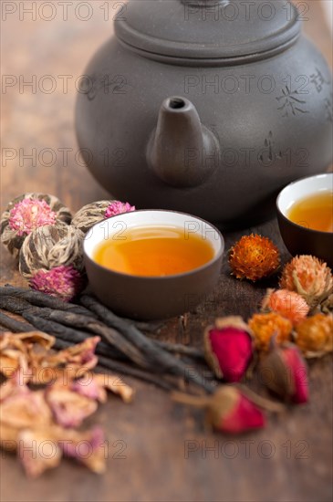 Chinese style herbal floral tea over wood table with raw ingredients