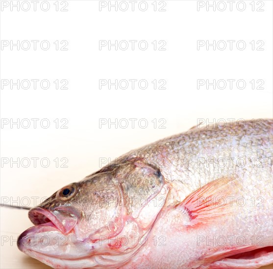 Fresh whole raw fish on a wooden table ready to cook